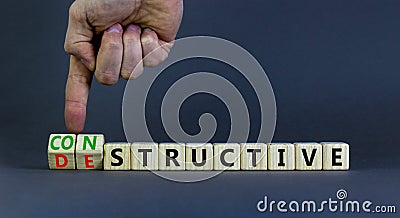 Destructive or constructive symbol. Businessman turns cubes and changes the concept word Destructive to Constructive. Beautiful Stock Photo