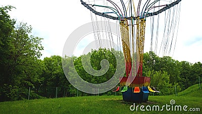 Detached entertainment amusement Park ride. Seats on long chains. Nobody rides. Around the silence and the forest Stock Photo