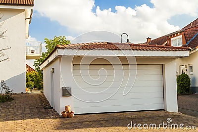 Detached white garage with orange brick tile roof Stock Photo