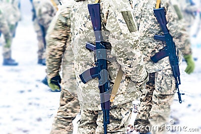 A detachment of soldiers with Kalashnikov assault rifles stand in formation to prepare for battle and offensive Stock Photo