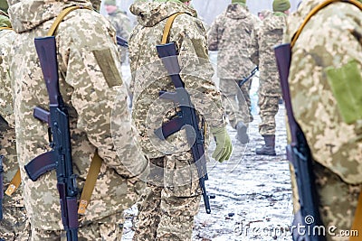 A detachment of soldiers with Kalashnikov assault rifles stand in formation to prepare for battle and offensive Editorial Stock Photo