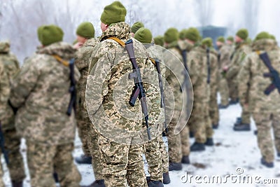 A detachment of soldiers with Kalashnikov assault rifles stand in formation to prepare for battle and offensive Stock Photo