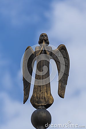 Detail of beautiful bronze statue of an angel with wings against the sky. Beautiful angel with a blue sky background with space Editorial Stock Photo