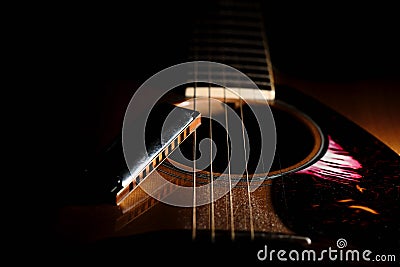 Detail of a blues harmonica near the sound hole of an acoustic g Stock Photo