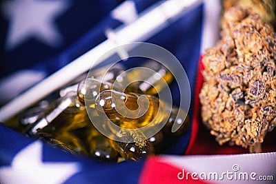 Detail of cannabis CBD oil capsules and bud in front of american Stock Photo