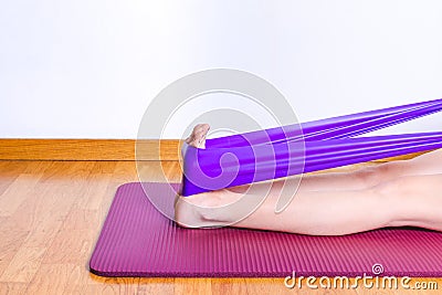 Detail of caucasian woman stretching calves with gym elastic band Stock Photo