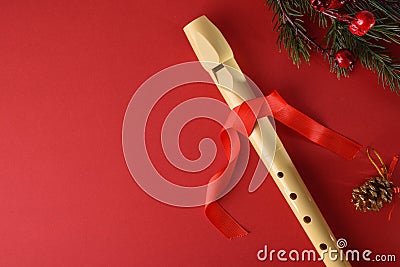 Detail of traditional plastic recorder on red with Christmas decoration Stock Photo