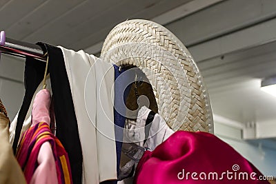 Detail closeup of clothing rack of costumes backstage at the theater with straw cowboy hat hanging on end - selective focus Stock Photo