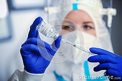 Detail closeup of syringe needle and ampoule , nurse taking injection shot,hands in blue protective gloves holding Stock Photo