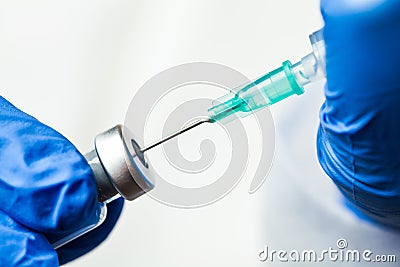 Detail closeup of syringe needle in ampoule vial,UK nurse taking injection shot Stock Photo