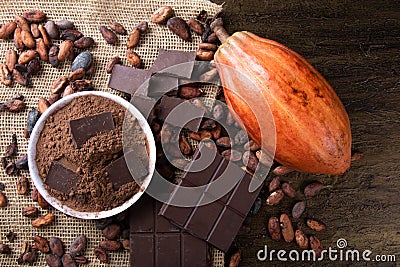 Detail of cocoa fruit with pieces of chocolate and cocoa powder on raw cocoa beans Stock Photo