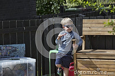 Cute little blonde boy is eating a choc-ice Editorial Stock Photo