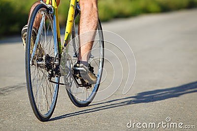 Detail of cyclist man feet riding bike on road. Stock Photo