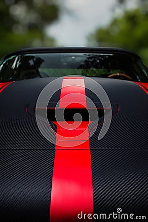 Detail of a dark racing sport car with bonnet scoop vent and red stripes Stock Photo