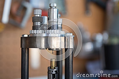 Detail of the decapping and resizing process of a 9mm case in the reloading press. Stock Photo