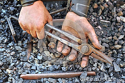 Detail of dirty hands holding pliers Stock Photo