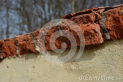 Detail of erosion of the roof of the crown of the wall, the fence of the garden. poorly fired bricks succumbed to erosion. water a Stock Photo