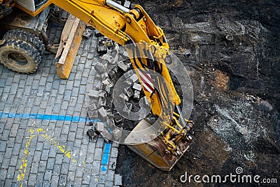 Detail of the excavator working on the cobblestone street reconstruction Stock Photo