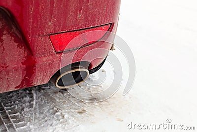 Detail on exhaust pipe of a red car parked on snow Stock Photo