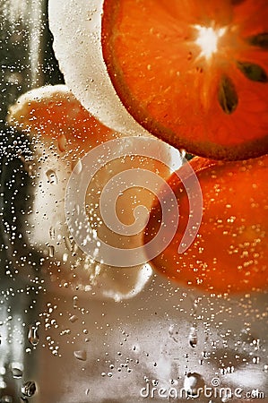 Detail of falling sliced orange into the glass of water Stock Photo