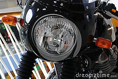 Detail of front mask with round headlight and classical oval orange winkers of former british, now indian made motorcycle Editorial Stock Photo