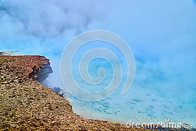 Detail of giant pools of blue covered in sulfur steam in Yellowstone Stock Photo