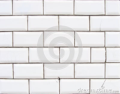 Detail of a glossy white beveled tile wall with damage Stock Photo