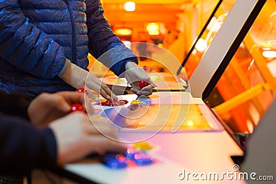 Detail on hands holding joysticks and red joysticks and playing a game on and old arcade Stock Photo