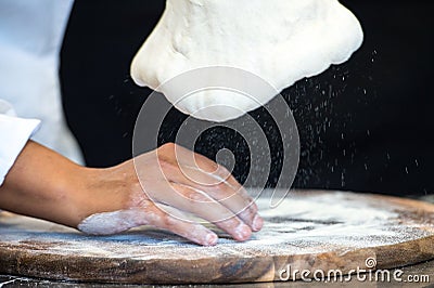 Detail of the hands of a pizza chef chef who works for the various stages of preparing a real Italian pizza homemade with yeast fl Stock Photo