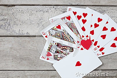 Detail of heart deck poker playing cars on wooden table Stock Photo