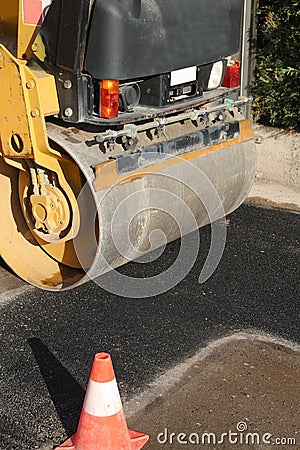 detail of an heavy road roller with one traffic cone Stock Photo