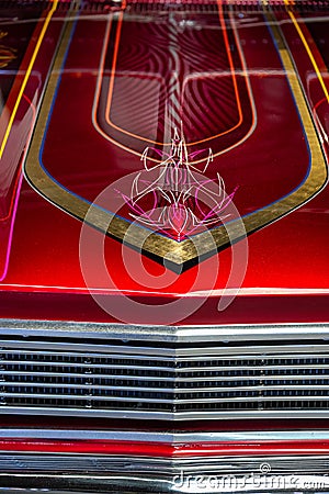 Detail of the hood of a red and chrome car with hand-painted lines Stock Photo