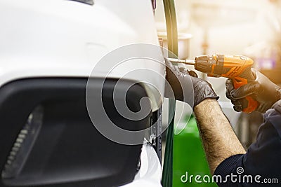 Detail image of mechanic hands with tool, changing tyre of car Stock Photo