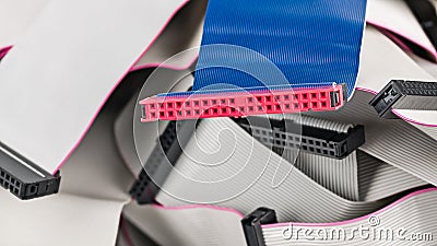 Blue parallel multi wire ribbon cable with pink connector on pile of white flat cords Stock Photo