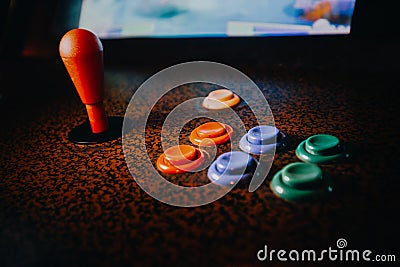 Detail on a joystick and button controls of a vintage arcade video game in a dark room Stock Photo