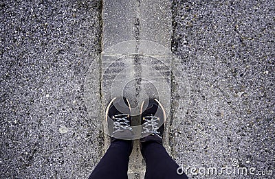 Woman's feet on the asphalt Stock Photo