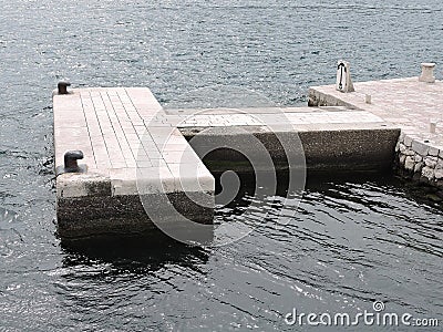 Small stone dock with old bollards for mooring ships on sea Stock Photo