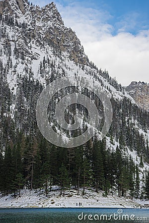 Detail of mountain face with rocks, snow and trees near Green lake Grunner see in sunny winter day. Famous tourist destination Stock Photo