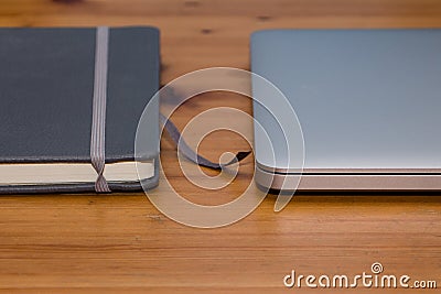 Detail of a notebook and laptop on wooden table Stock Photo