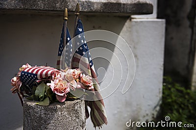 Detail of old American flags and flowers placed in a tomb in a New Orleans cemetery, in Louisiana Stock Photo