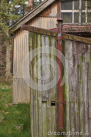 Detail of an old conical capped small stove chimney in an outhouse attached to a derelict wooden Religious building Stock Photo