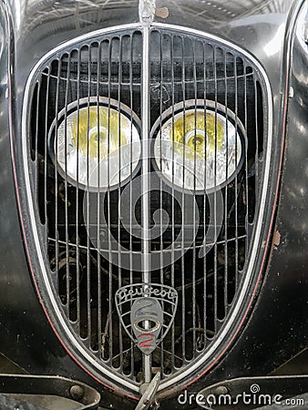 Detail of old french car with radiator grille and round light, vintage and retro background Editorial Stock Photo