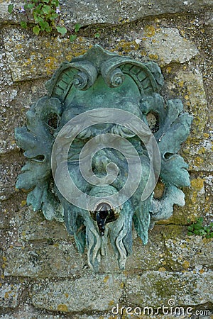 Detail of old greenman mask on stone wall Stock Photo