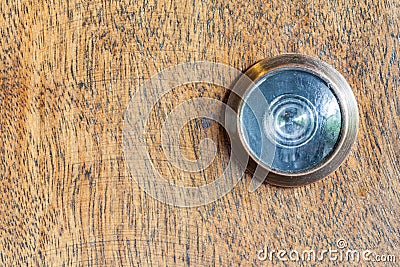 Detail of old lens peephole on wooden door background. Stock Photo