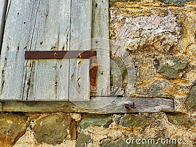 Detail of Old Stone House With Rough Wooden Window Shutter Stock Photo