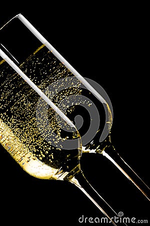 Detail of a pair of tilted flutes of champagne with golden bubbles Stock Photo