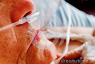 Detail of a patient breathing oxygen through a plastic nasal cannula, elderly woman with breathing problems in a hospital Stock Photo