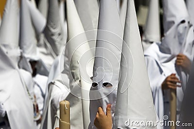 Detail penitent white holding a candle Stock Photo