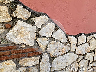 Detail of a pink wall with stones in various shades of beige. Stock Photo