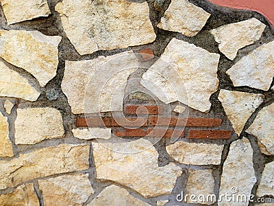 Detail of a pink wall with stones in various shades of beige. Stock Photo